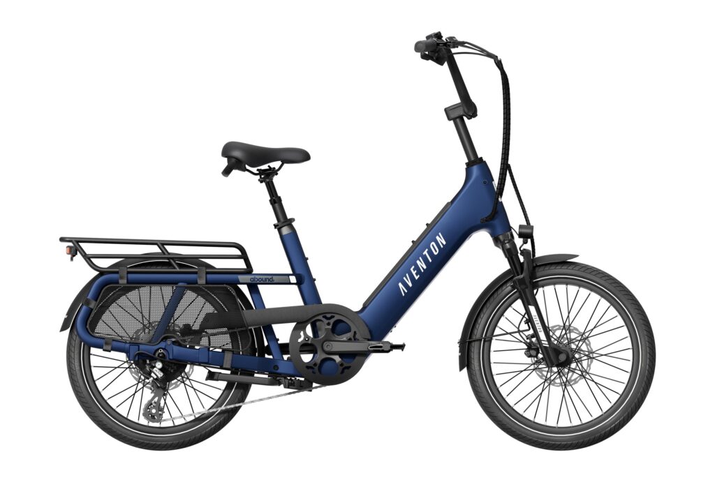 Side view of a cobalt-blue Aventon Abound SR compact cargo e-bike with a rear rack, small 20-inch wheels, a step-through frame and upright handlebars, on a white background.