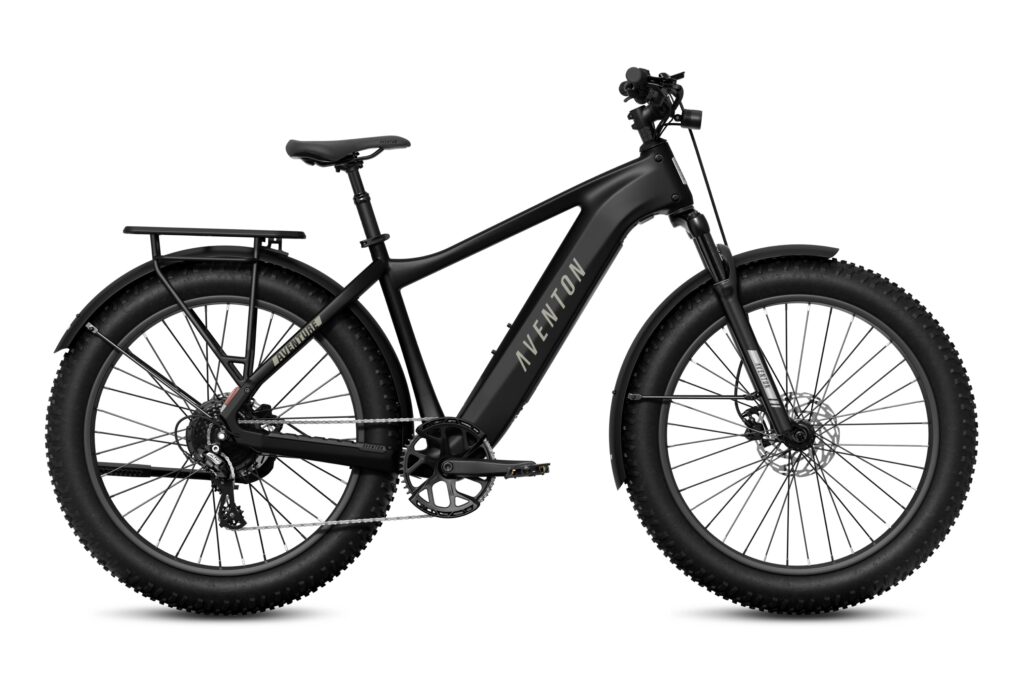 Side view of a matte black Aventon Aventure 3 fat-tire electric bike with a rear rack, black fenders, front suspension fork and 4-inch knobby tires on a white background