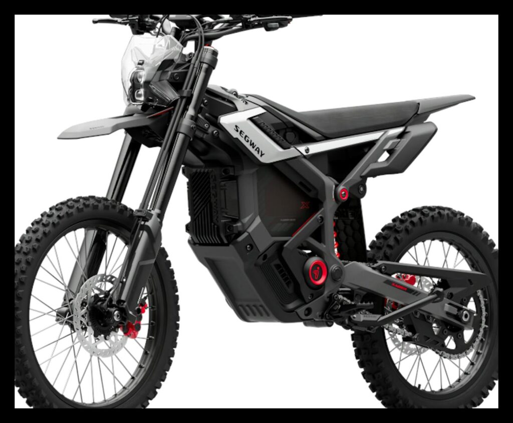 Segway Xaber 300 electric dirt bike in black with silver and red accents, three-quarter front view on a white background, showing its motocross-style frame, long-travel front fork, knobby spoked wheels, red brake calipers and flat seat.